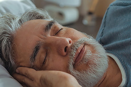 A man, near middle-age, is pictured sleeping peacefully.