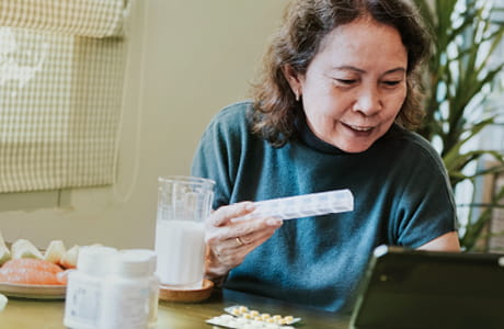 A woman checking online to pay less for medications