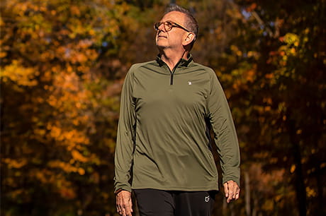 Retired physician Charlie White takes a walk in the woods.