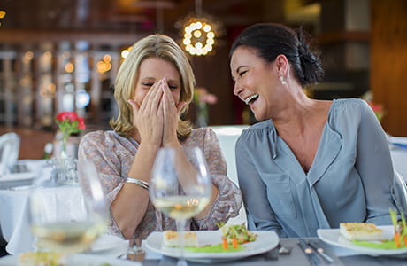 2 women laughing after one of them sneezed