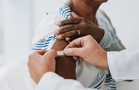 A patient receives a vaccine from the clinic's provider.