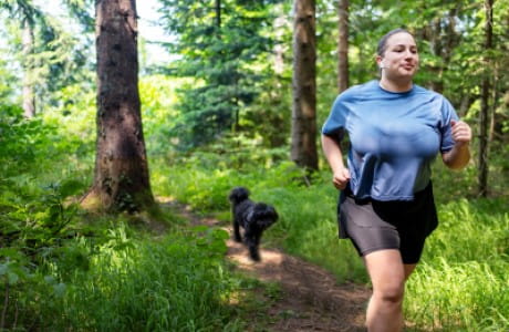 A woman running with a dog.