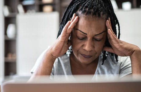 A woman holding her hands to her head