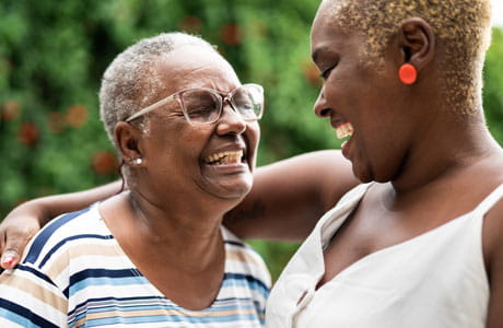 Two smiling women sharing a hug