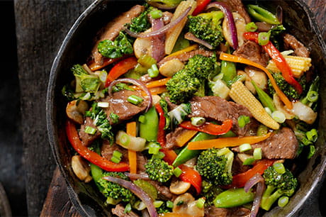 Stir-fried orange beef being prepared.