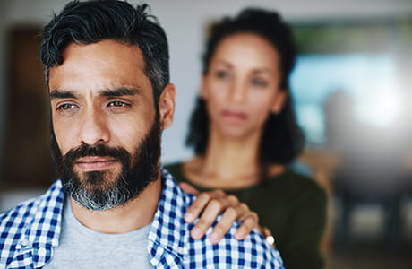A woman comforting her distraught husband.