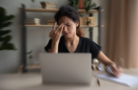 A woman having a dizzy spell touching her forehead.