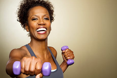 Woman exercising with purple dumbbells