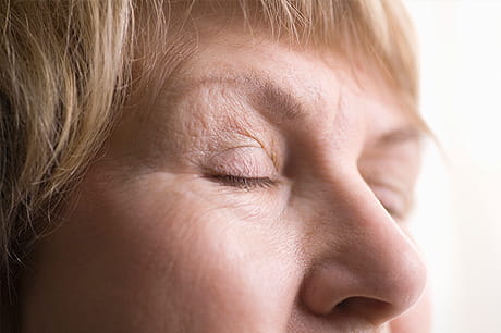 Older woman with wrinkles near her eyes
