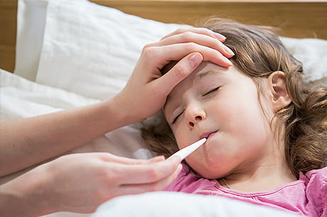 Parent taking daughter's temperature 