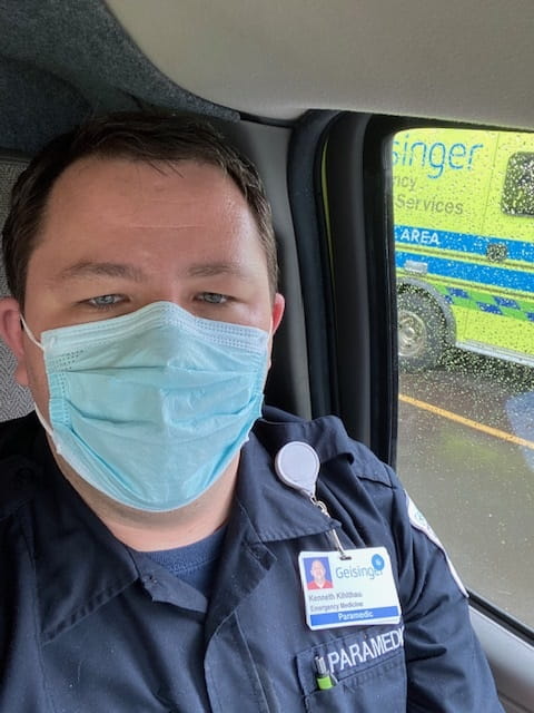 Geisinger paramedic Ken Kihlthau sits in his ambulance wearing his face mask.