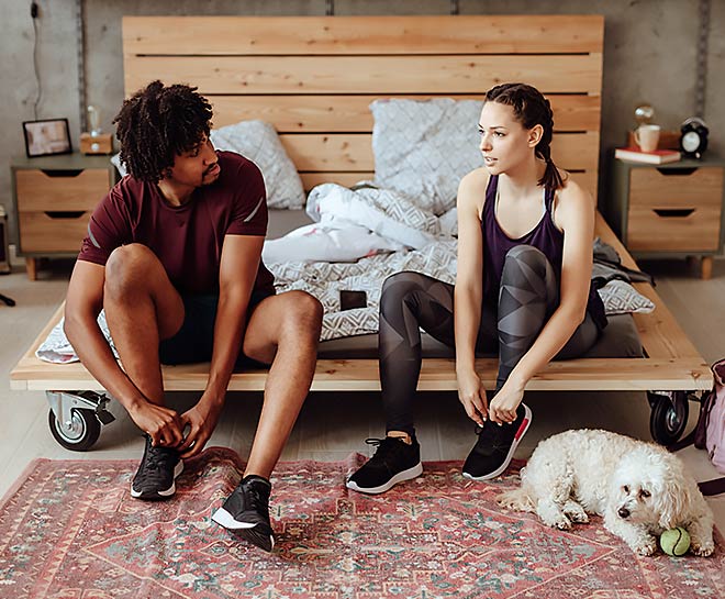 Prior to running, a young couple inserts orthodics into their athletic shoes.