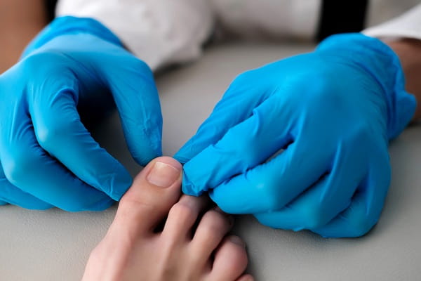 A podiatrist's hands examining a foot
