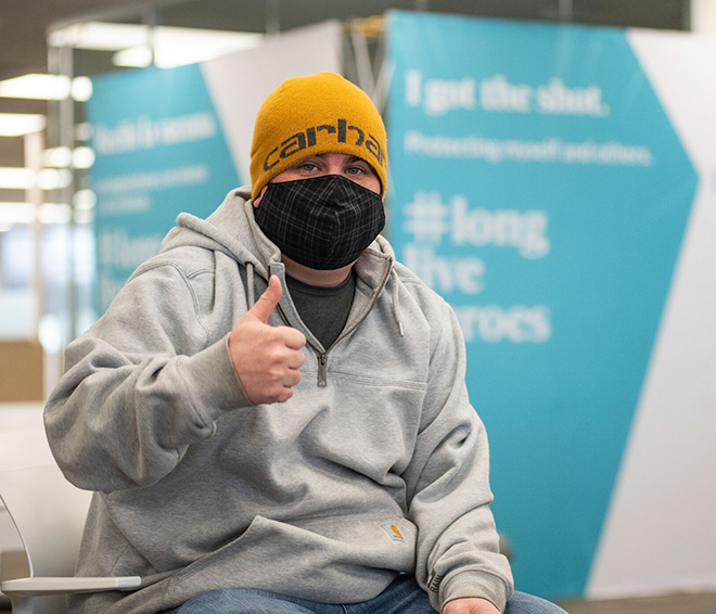 Teen awaiting COVID vaccine injection at a walk-in clinic.