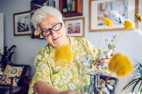 woman in glasses arranging flowers