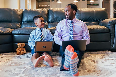 A father and son working together from their home in business attire.
