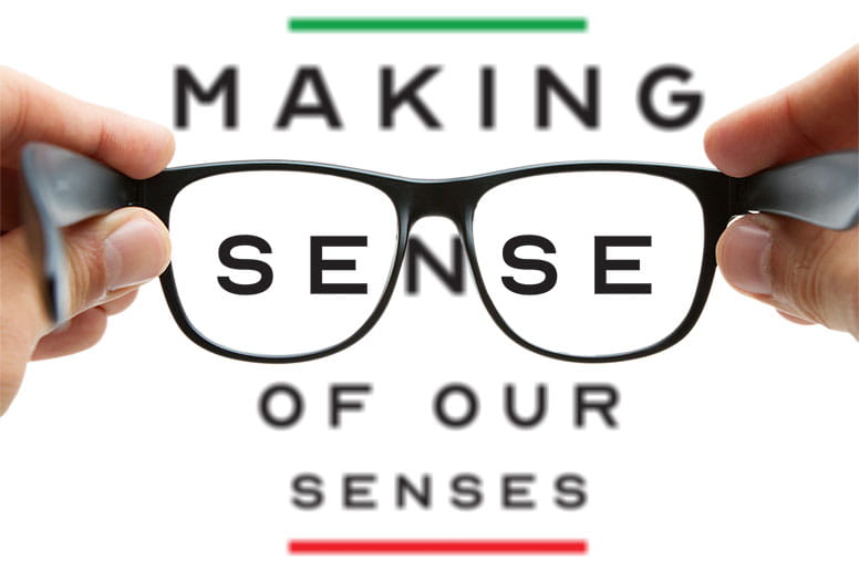 Photo illustration of an eye chart with hands holding a pair of glasses.