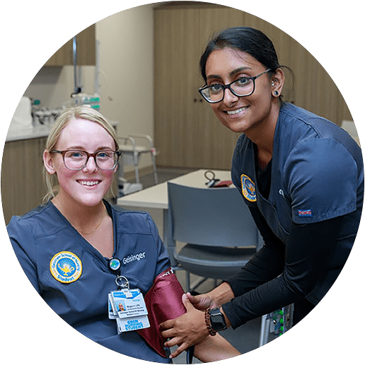 A nursing student applies a blood pressure cuff to a classmate.