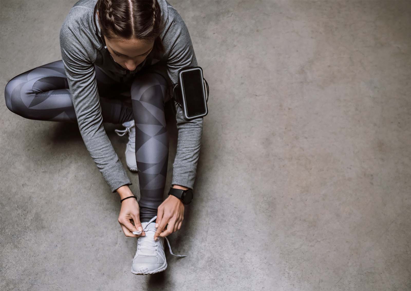 A you woman prepares for a training run by stretching.