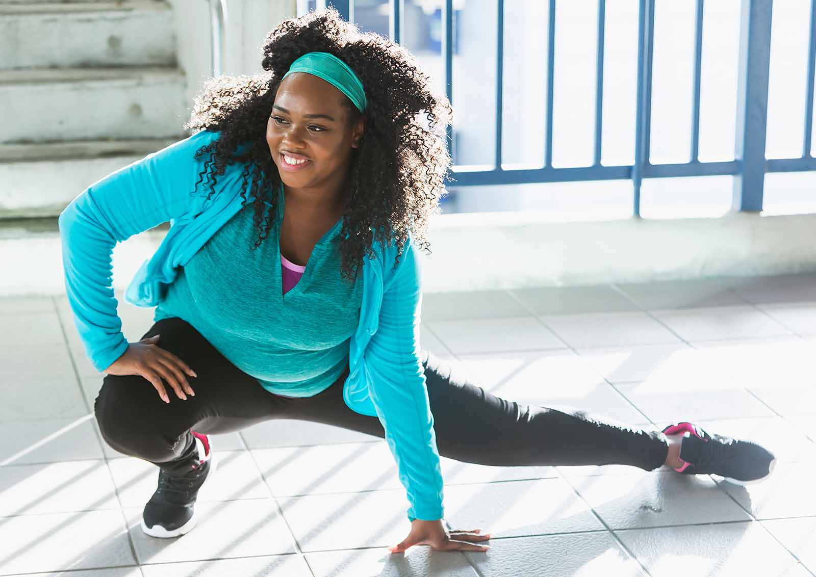 A young female stretches prior to an exercise routine.