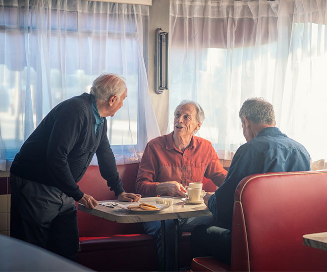 Three older gentlemen enjoying a meal together at a local diner.