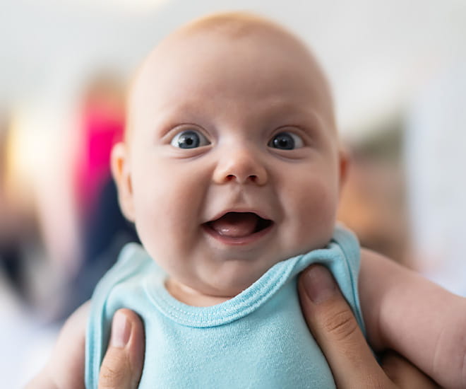 Happy infant being held.