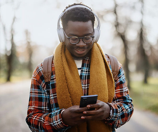 Adult male listening to podcast while outside.