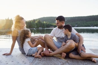 A family on the pier warm summer day having good time