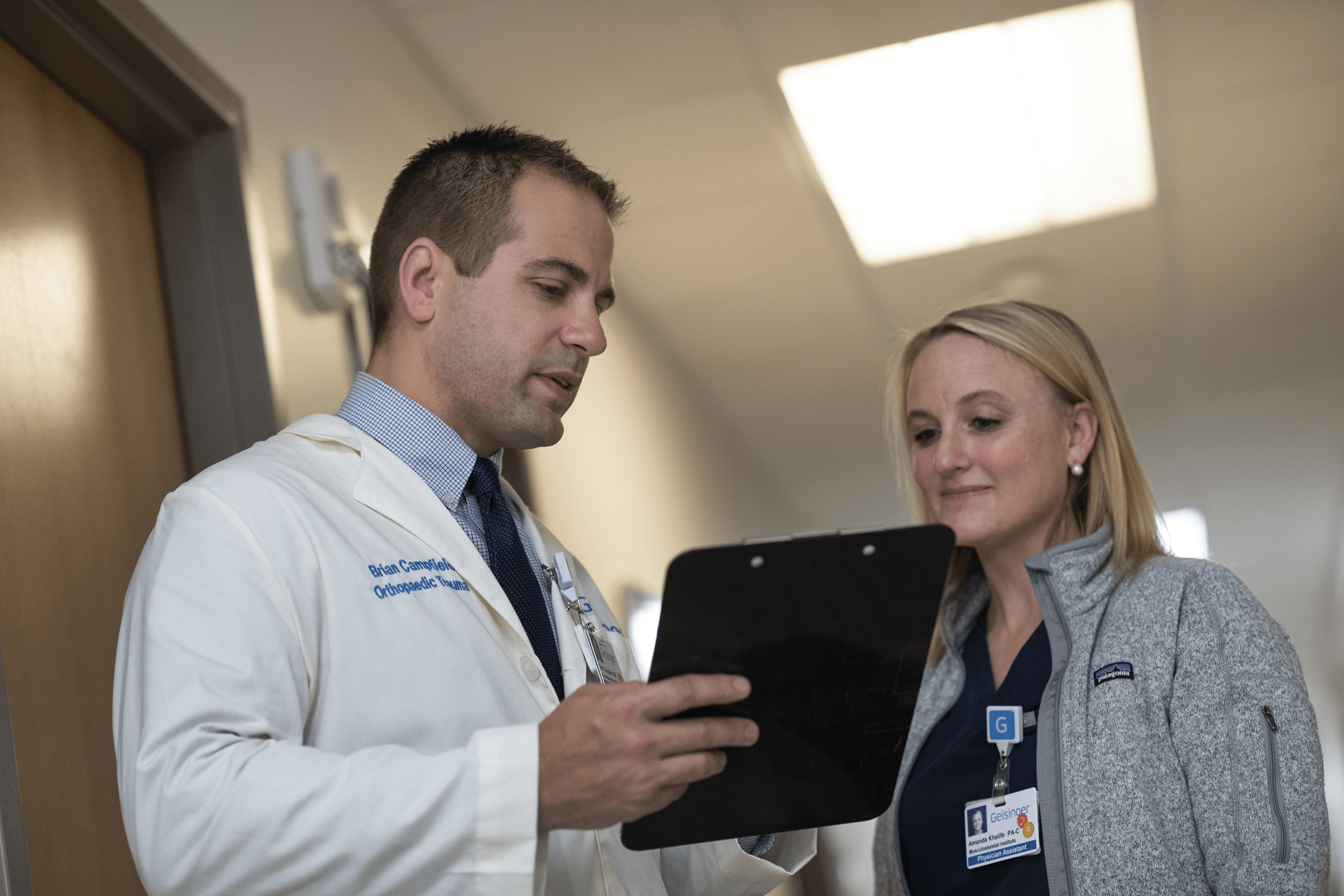 Two doctors discuss results on a clipboard
