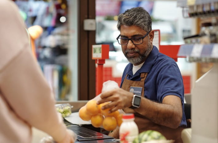 a male cashier working at a grocery store