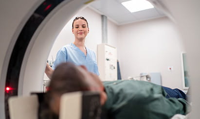 A MRI tech assist a patient in the machine