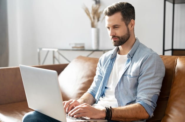 Un hombre joven mirando su computadora portátil