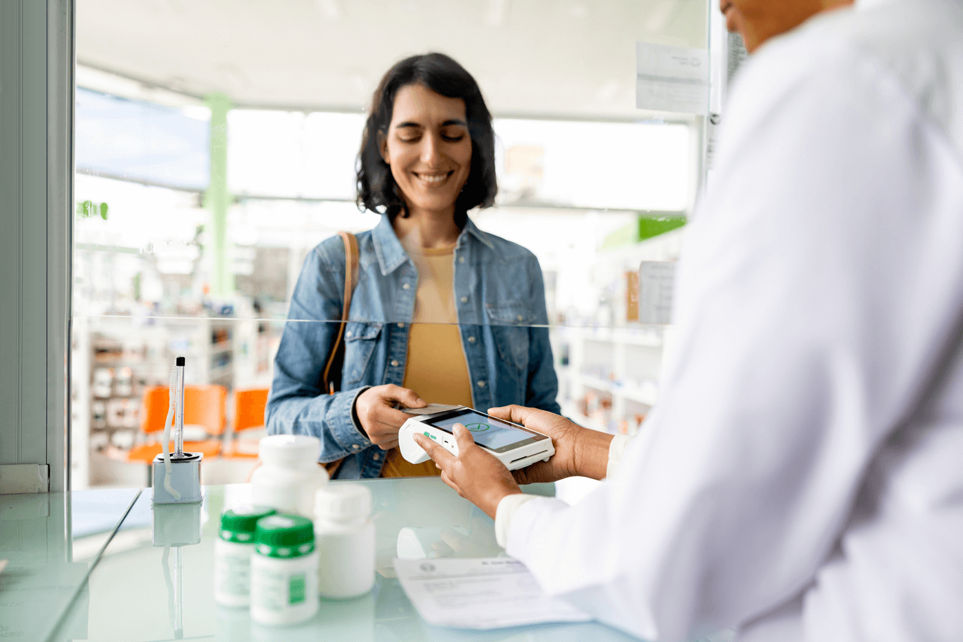 A woman pays for her prescription at a pharmacy