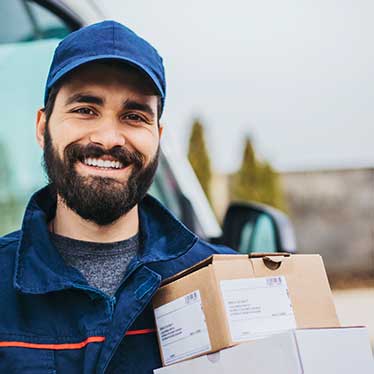 Hombre sonriendo y sosteniendo paquetes