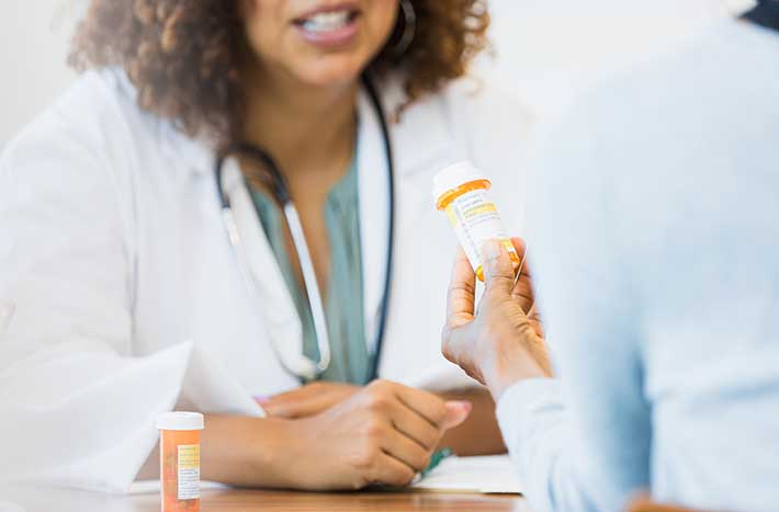 Médico revisando el medicamento recetado con el paciente