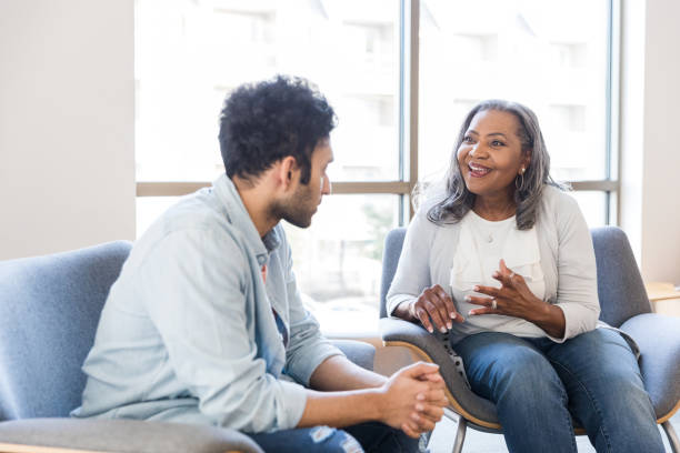 Two seniors embrace while chatting at home