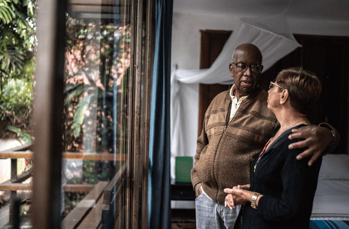 Dos adultos mayores se abrazan mientras hablan en casa