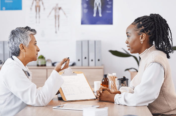 Doctor with patient in office going over results on clipboard