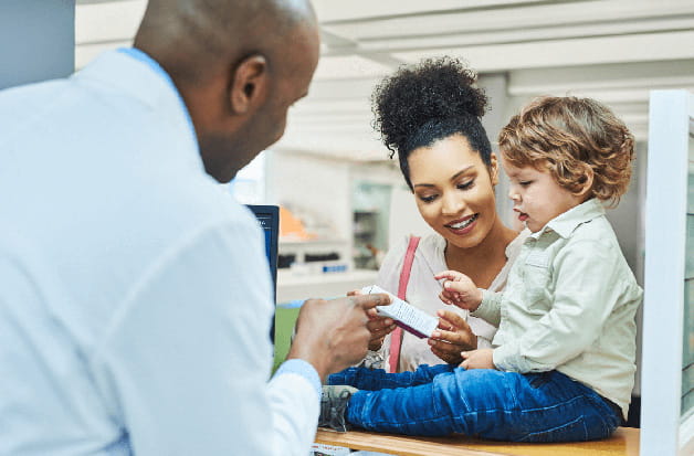 Padre retirando un medicamento recetado con sus hijos