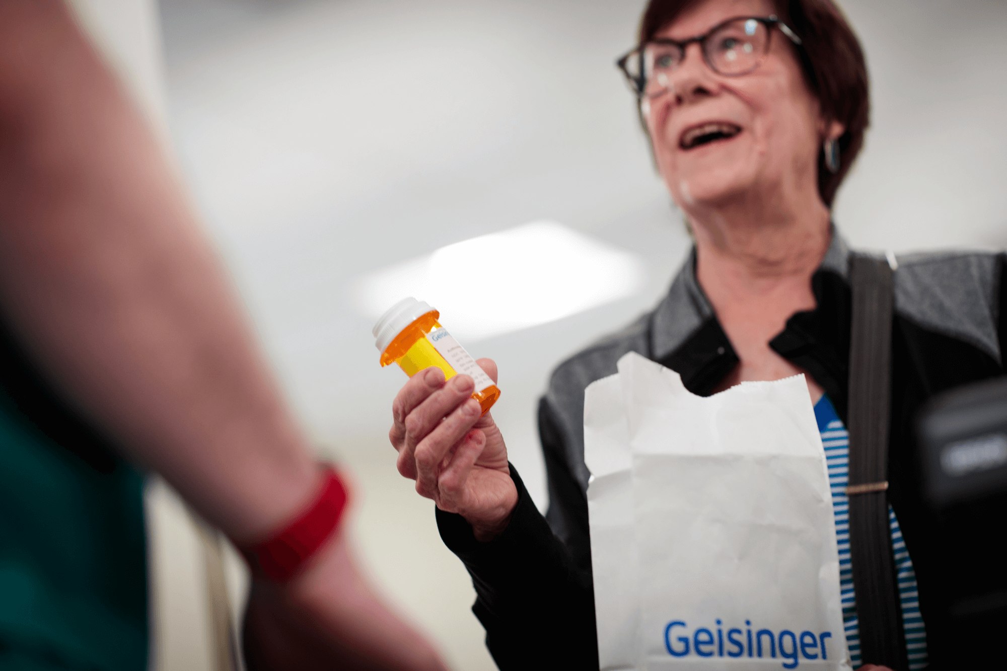 Una mujer sostiene una bolsa con medicamentos recetados de Geisinger