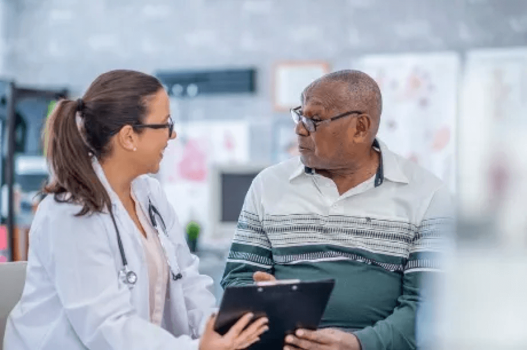 An elderly patient sits with a doctor