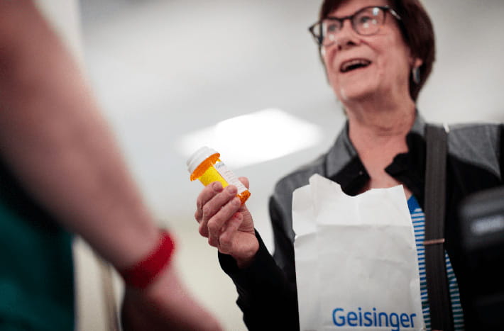 A woman holds a prescription pill bottle 