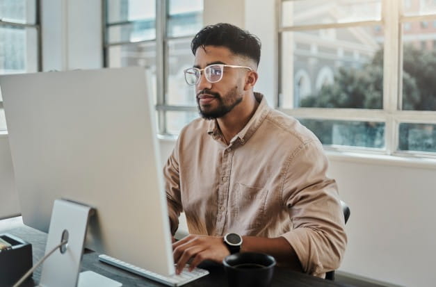 A male app developer sitting at his computer