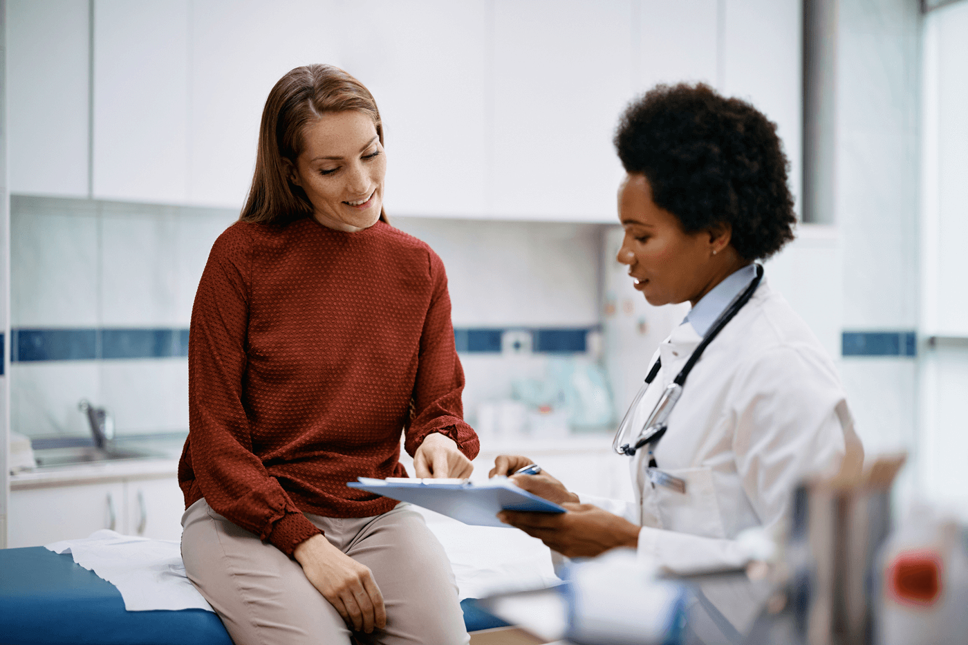 A doctor and patient discuss results on a clipboard