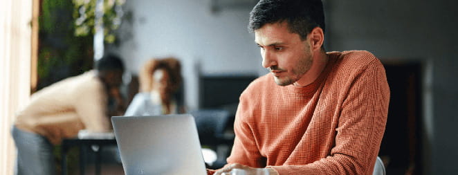 Un hombre trabaja con una computadora portátil en una oficina