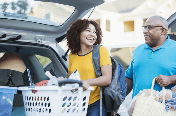 A young woman is packing up her car to move out of her parents' house