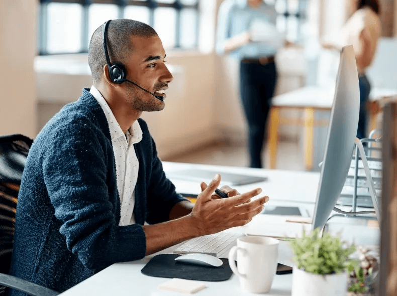 A Medicare employee with a headset takes a call at their desk