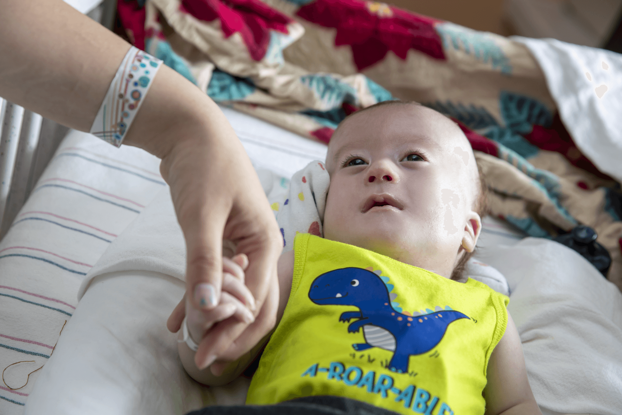 Someone holds hands with a newborn child