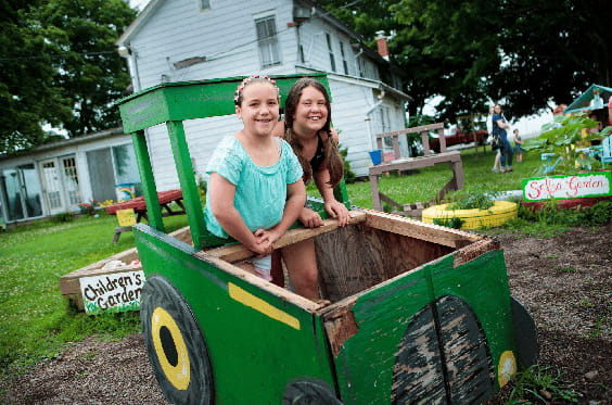 Dos niños juegan en un tractor de juguete grande