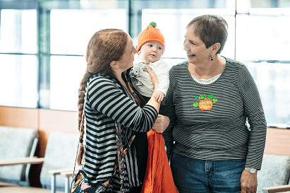 Two seniors holding a baby